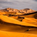 Sahara desert adventure from Fes to Merzouga with camel caravan crossing Erg Chebbi dunes and luxury desert camp stay.