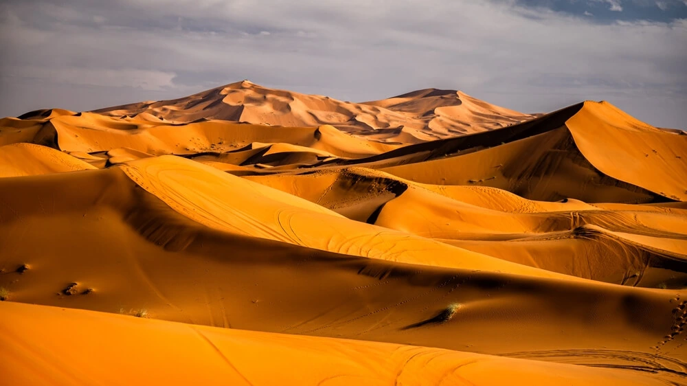 Sahara desert adventure from Fes to Merzouga with camel caravan crossing Erg Chebbi dunes and luxury desert camp stay.